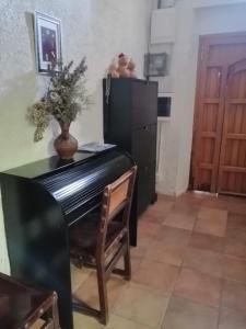 a dining room with a black refrigerator and a table at CAL BENAIGES in Tartareu