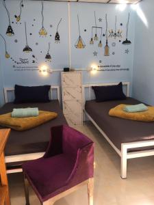 1 dormitorio con 2 camas, silla y luces en World Citizen GuestHouse, en Ko Pha Ngan