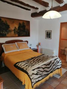 a bedroom with a bed with a zebra print blanket at CAL BENAIGES in Tartareu
