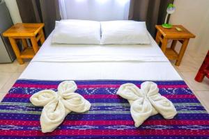 uma cama com duas toalhas em cima em Baki Divers and Beach Resort em Dauin