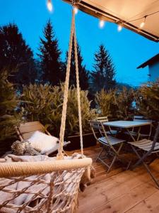 a rope swing with a table and chairs on a patio at New, terrasse, vue Mont Blanc in Chamonix-Mont-Blanc