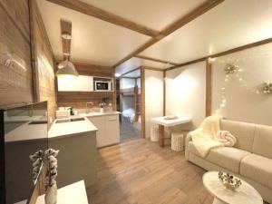 a living room with a couch and a kitchen at New, terrasse, vue Mont Blanc in Chamonix-Mont-Blanc