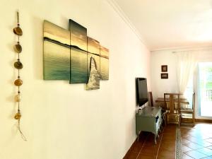 un soggiorno con tre dipinti sul muro di CASA AZUL Mojácar a Mojácar