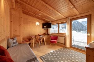 een kamer met een bed en een bureau in een hut bij Apartments Heritage House Margherita in Santa Cristina in Val Gardena
