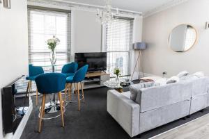 a living room with a couch and a table and chairs at Stunning 2 Bed in the Centre of Cheltenham! in Cheltenham