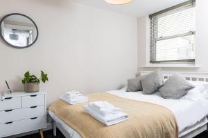 um quarto branco com uma cama e um espelho em Stunning 2 Bed in the Centre of Cheltenham! em Cheltenham
