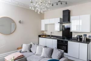 a living room with a couch and a kitchen at Stunning 2 Bed in the Centre of Cheltenham! in Cheltenham