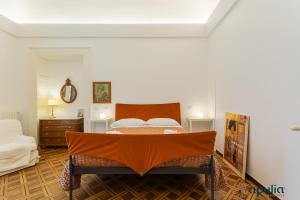 een slaapkamer met een bed met een oranje deken erop bij Dimora Abate Gimma by Apulia Accommodation in Bari