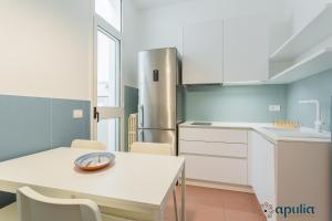 een keuken met een witte tafel en een koelkast bij Dimora Abate Gimma by Apulia Accommodation in Bari