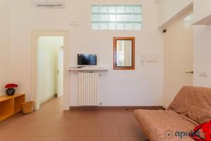een woonkamer met een bank en een tv aan de muur bij Dimora Abate Gimma by Apulia Accommodation in Bari