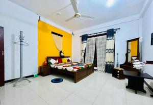 1 dormitorio con cama y pared amarilla en Rathnayake Rest, en Badulla