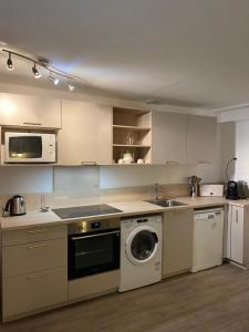 a kitchen with a washing machine and a washer at Domaine du golf lacanau Piscine chauffée 3 chambres in Lacanau