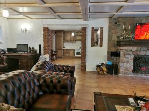 a living room with leather furniture and a stone fireplace at Ąžuolas 