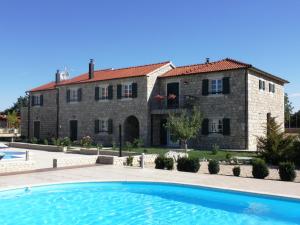een groot stenen huis met een zwembad ervoor bij Pansion Skelin in Drinovci