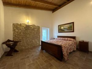 - une chambre avec un lit et un mur en pierre dans l'établissement Antica dimora l'Archetto, à Prossedi