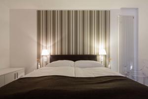 a bedroom with a large bed with two lamps at Boardinghouse M&uuml;nster in M&uuml;nster