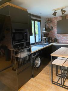 a kitchen with a washer and dryer next to a stove at La Buissonnière, Veulettes sur Mer, entre mer et campagne in Veulettes-sur-Mer