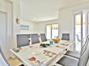 a white dining room with a white table and chairs at Exklusive 4-Sterne-Villa Mare - WLAN - Pool - Grill in Plovanija
