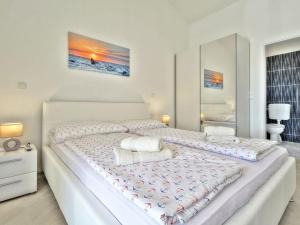 a white bedroom with a large white bed with pillows at Exklusive 4-Sterne-Villa Mare - WLAN - Pool - Grill in Plovanija +10 photos