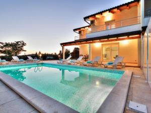 a swimming pool in front of a house at Exklusive 4-Sterne-Villa Mare - WLAN - Pool - Grill in Plovanija +8 photos