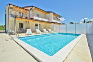 a swimming pool in the backyard of a house at Exklusive 4-Sterne-Villa Mare - WLAN - Pool - Grill in Plovanija