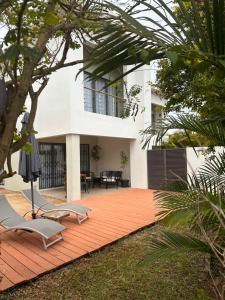 a patio with two lounge chairs and a house at Modern Villa in Grand Bay - Short Walk to Beach in Grand Baie