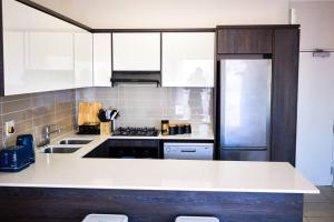 a kitchen with a white counter and a refrigerator at 1d - Serene Retreat of Parklands in Cape Town +6 photos