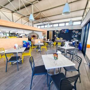 a restaurant with tables and chairs in a room at 1d - Serene Retreat of Parklands in Cape Town