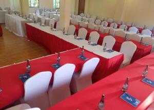 a conference room with red and white tables and chairs at Sabby Grand Hotel in Ithumba