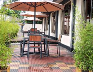 a table and chairs with an umbrella on a patio at Sabby Grand Hotel in Ithumba