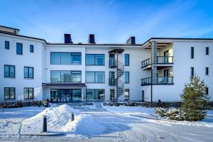 a large white building with snow in front of it at Regatta Seaside Suite in Hanko in Hanko