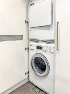 lavadora y secadora en una lavandería blanca en Regatta Seaside Suite in Hanko, en Hanko