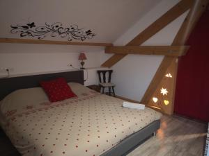 a bedroom with a bed with a red pillow at La Fruitière d'Arith in Arith