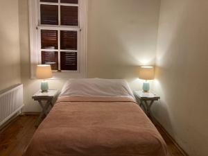 a bed in a room with two lamps on tables at Maris , Greek House @ City Center ALSANCAK in Konak