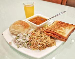 um prato branco de comida com uma sanduíche e torradas em Arton Regency em Mumbai