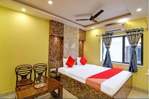 een slaapkamer met een bed en een tafel en stoelen bij Hotel Divine Chariot in kolkata
