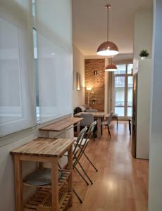 uma sala de estar com mesas e cadeiras e uma cozinha em Rosa 2 Bedrooms in City Center em Málaga