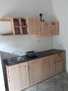 a kitchen with a sink and wooden cabinets at Harmonic villa in Weligama +8 photos