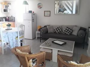 ein Wohnzimmer mit einem Sofa und einem Tisch in der Unterkunft La maison des enfants in Mèze