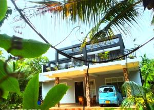 medahena في تانجالي: سيارة زرقاء متوقفة أمام منزل