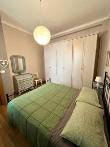 a bedroom with a green bed and a tv at Gionas - Casa indipendente in zona strategica in Milan