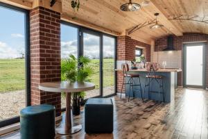 a kitchen with a brick wall and a table and stools at Brick Barn - Luxury Barn Conversion by River Avon! in Cropthorne