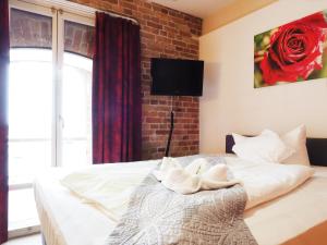 a bedroom with a white bed with a brick wall at Speicher Barth - Superior-Hotel in Barth