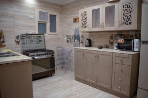 a kitchen with white cabinets and a stove top oven at شقه فندقيه مواجهه للأهرامات. Hotel Apartment in Cairo