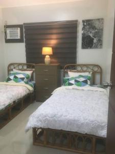 1 dormitorio con 2 camas y una lámpara en un tocador en Apartment 2 in Bacolor near San Fernando, en Bacolor