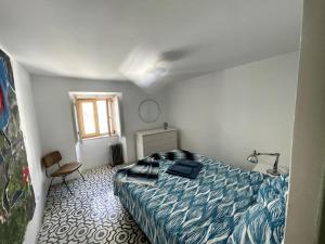 a bedroom with a bed and a chair and a window at Zen House in Sines