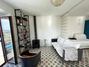 Zen House في سينيس: غرفة معيشة مع أريكة بيضاء ونافذة