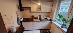 a small kitchen with white cabinets and a sink at Apartament na Bałtyckiej in Kołobrzeg