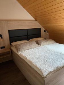 uma cama num quarto com tecto em madeira em Fischers Ferienhaus em Alken