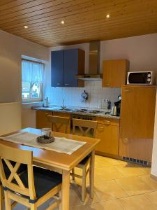 uma cozinha com uma mesa de madeira, uma mesa e cadeiras em Fischers Ferienhaus em Alken